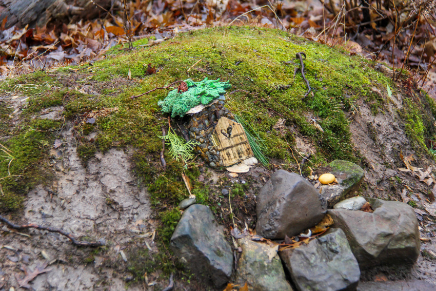 a fairy home with a heart door in a mossy covered mound with rocks