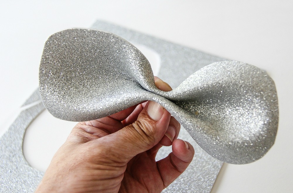 hand holding silver foam shaped like ears