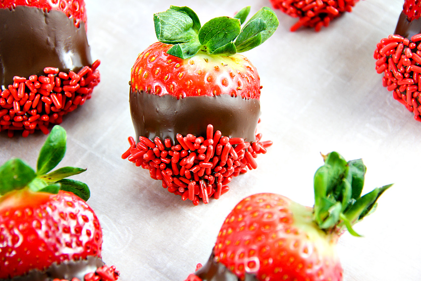 strawberries dipped in milk chocolate and red nonpareils