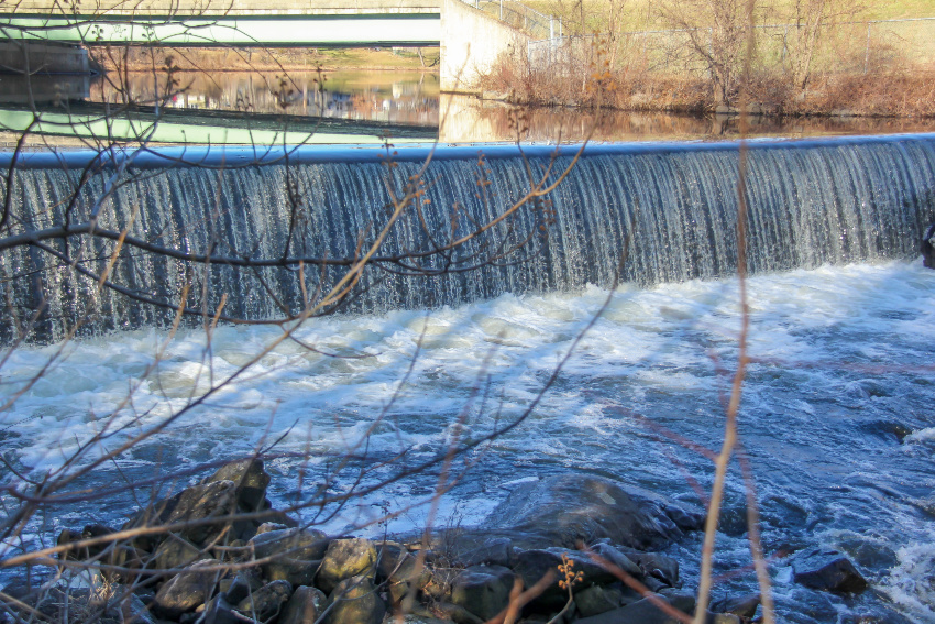 dam and waterfall flowing into a river