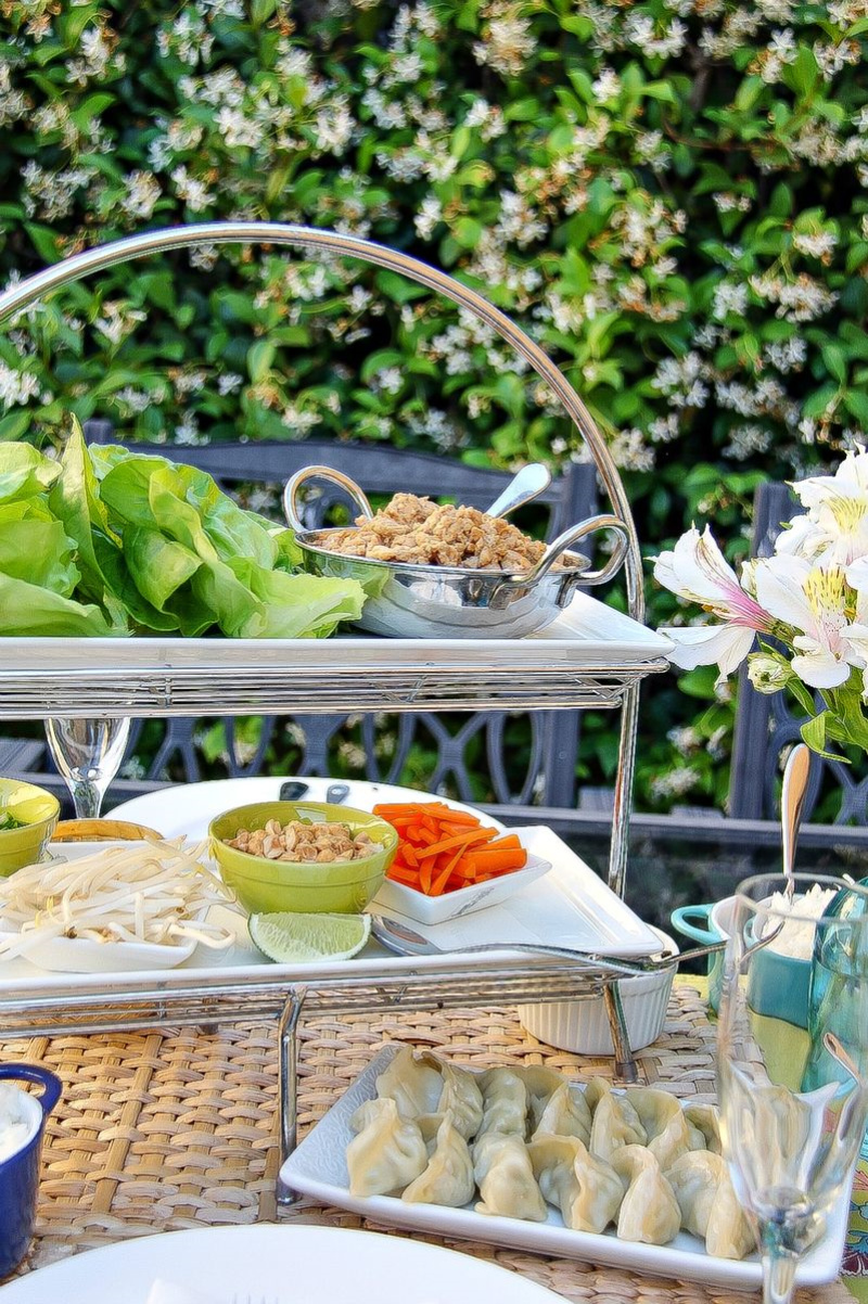 a tiered food stand with toppings and ingredients for lettuce wraps