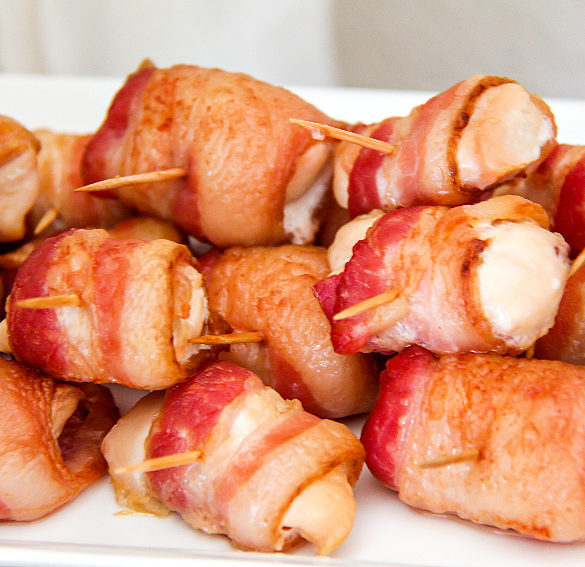 bacon wrapped around chicken pieces with toothpicks in the middle