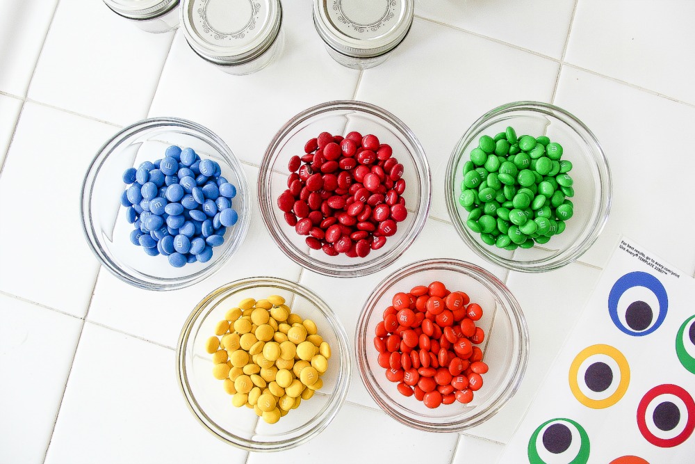 colorful M&M's candy in glass jats with monster eye labels