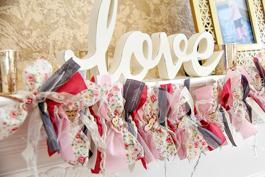 a romantic garland hanging on a fireplace mantel made of scrap fabric and ribbon