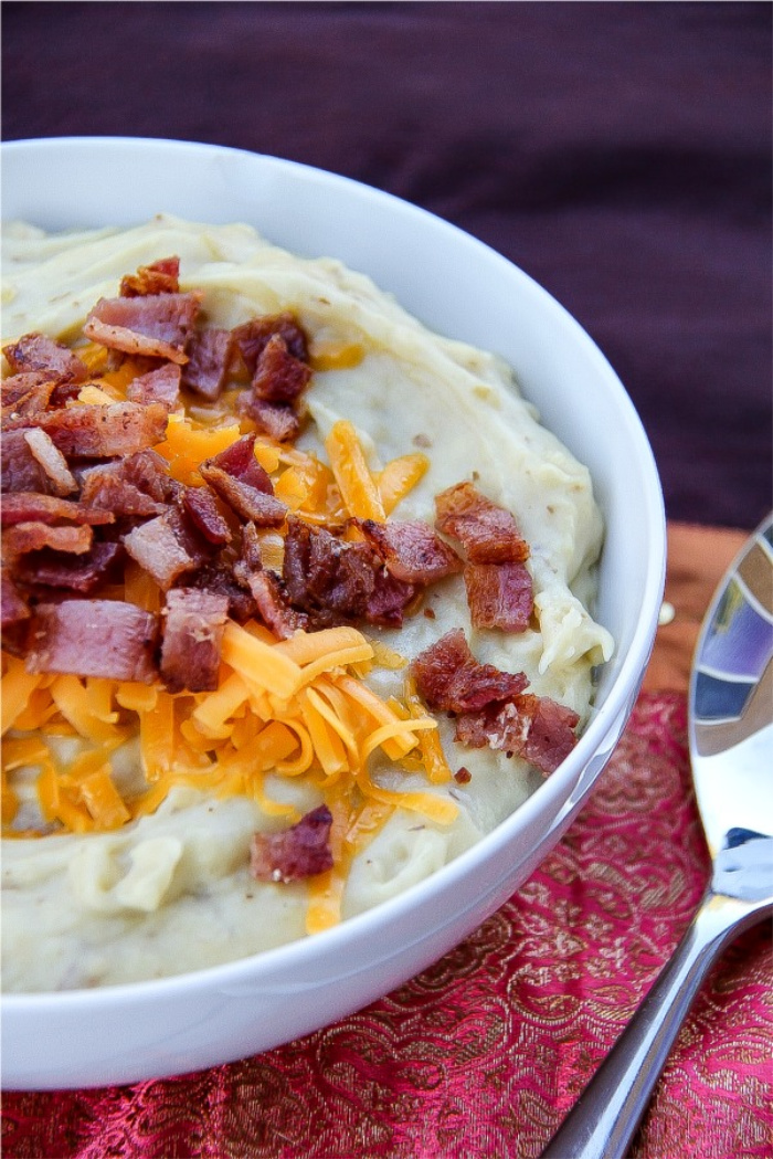 Slow cooker mashed potatoes topped with bacon and cheese.