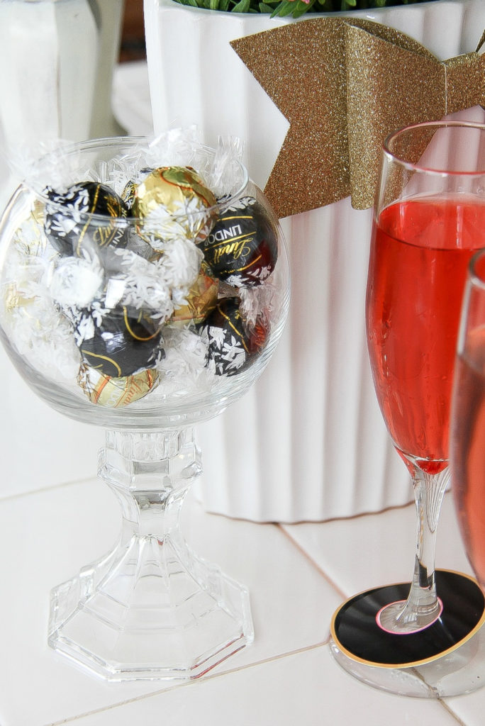 black and gold wrapped lindt balls in a glass jar