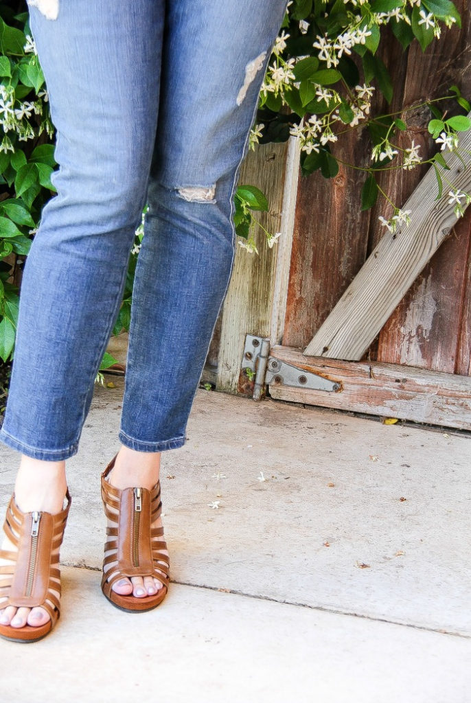 lady wearing torn denim jeans with brown sandals