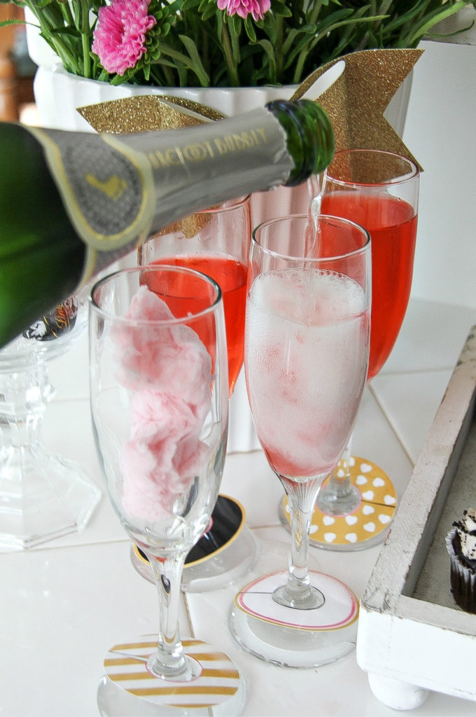 barefoot bubbly being poured into a champagne glass with cotton candy in it