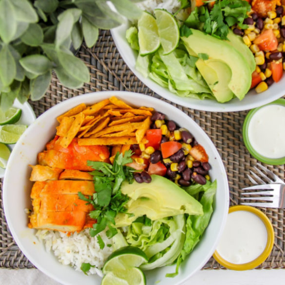 white bowls filled with chicken, rice, salsa, avocado and other taco ingredients