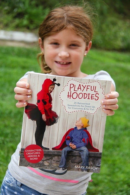 girl holding a Playful Hoodies book by Mary Rasch