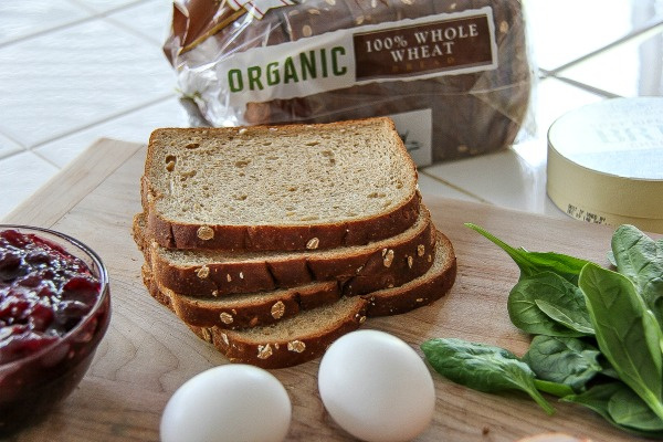 slices of whole wheat bread with eggs, cranberry sauce, and spinach