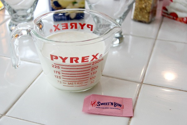 cream in a jug with a packet of sweet 'n low next to it
