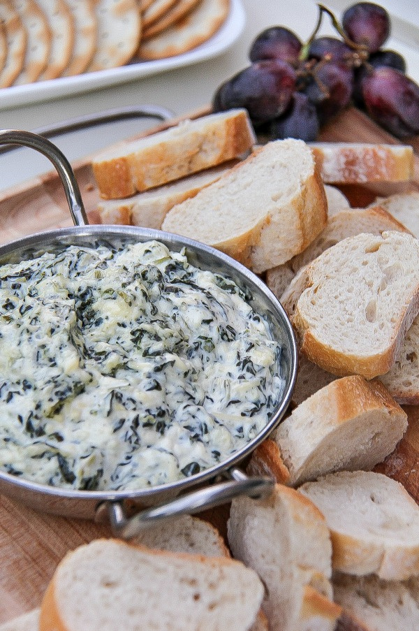 spinach and artichoke dip with bread and grapes