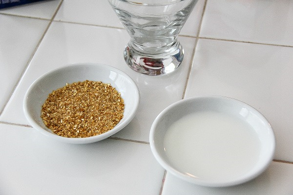 gold flecks and milk in shallow dishes next to a cocktail glass