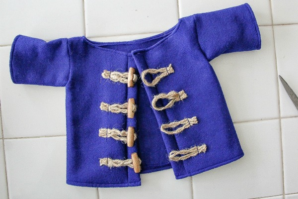 a blue felt coat handmade with rope and wood toggle closures