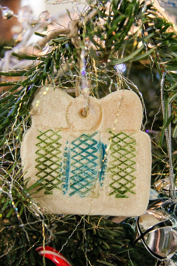 a handmade salt dough christmas present ornament hanging on a tree