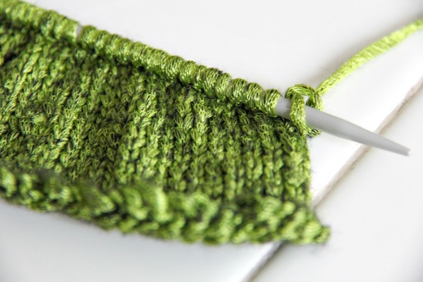 green knitting on a needle