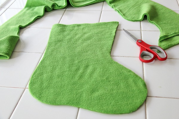 a christmas stocking being cut out of green fleece