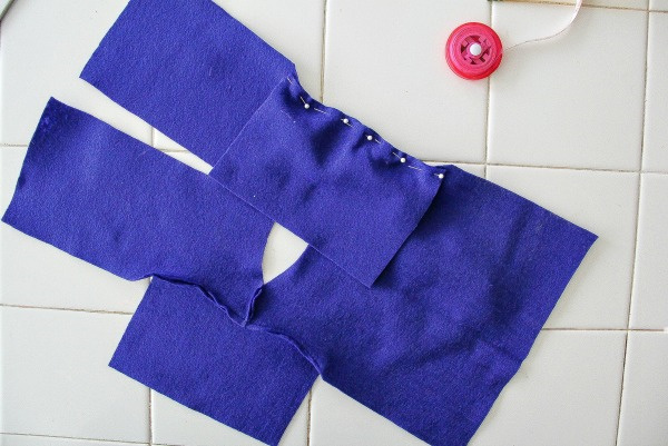 pieces of blue felt being pinned and sewn to make a coat