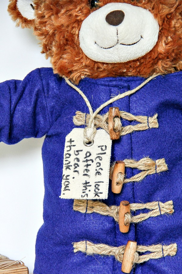 a tag hung around a bears neck that reads please look after this bear just like paddington