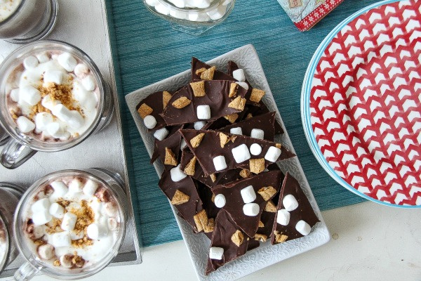s'mores bark and hot chocolate with plates set out on a table