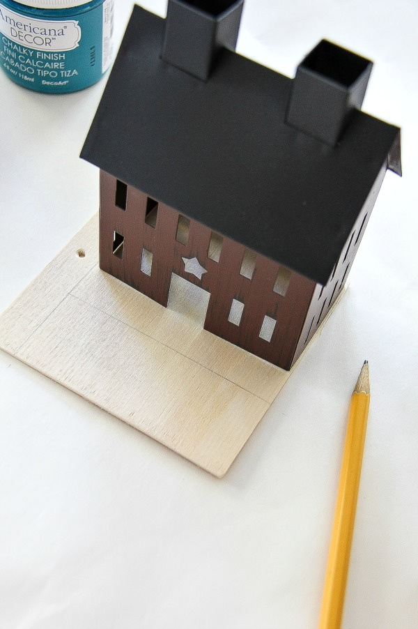 a tin house on top of a piece of plywood