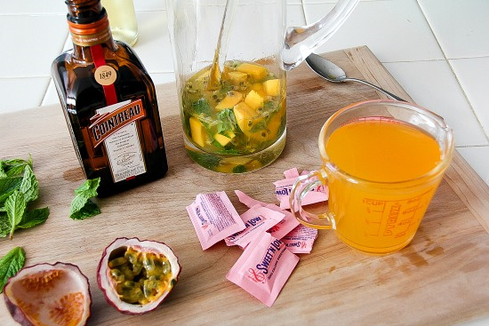 a bottle of cointreau, packets of sweet 'n low, and fresh passion fruit to make a cocktail