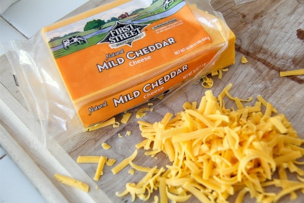 First Street brand mild cheddar cheese grated on a cutting board