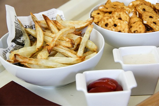 french fries and pretzels in bowls with dipping sauces