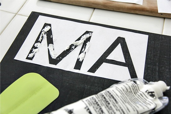 white clay being added to a chalkboard sign