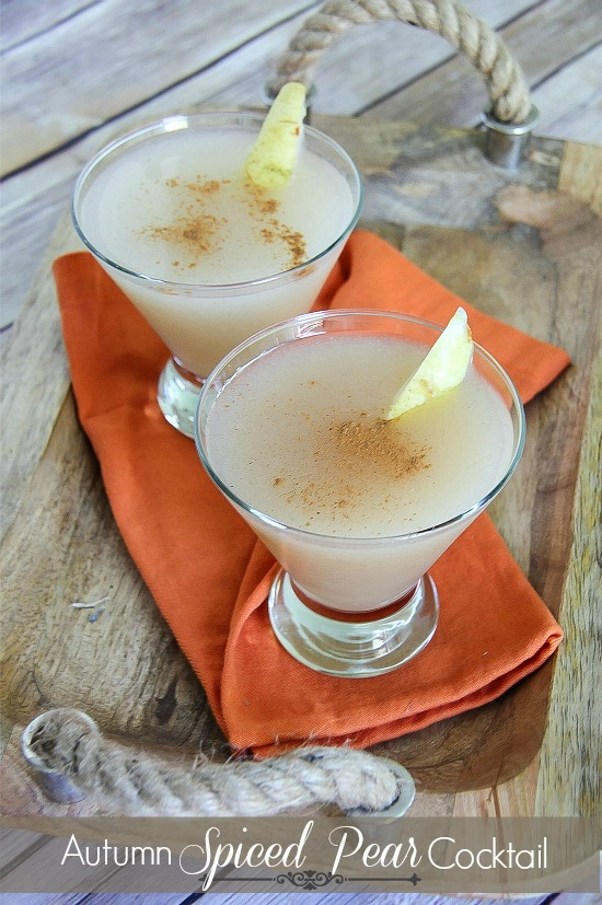 two pear vodka cocktails on on orange napkin and wood tray