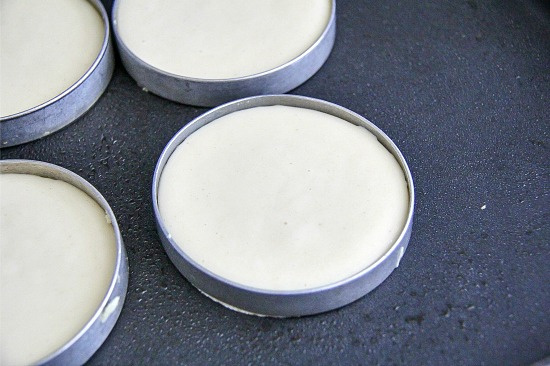 pancake mix in round metal rings on a pan