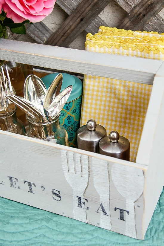 supplies for an outdoor party inside a vintage grey wood caddy