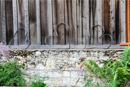 iron hearts along a wood fence in a garden