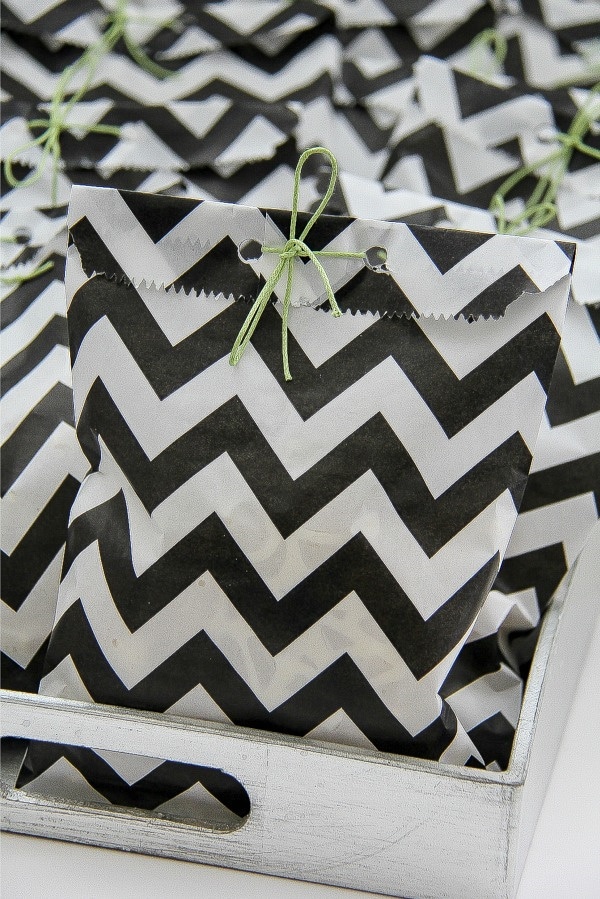 black and white party treat bags tied with green ribbon