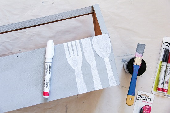 wood caddy with utensils being painted on it