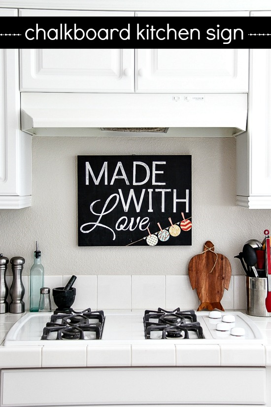 chalkboard kitchen sign hanging above the stove in a white kitchen