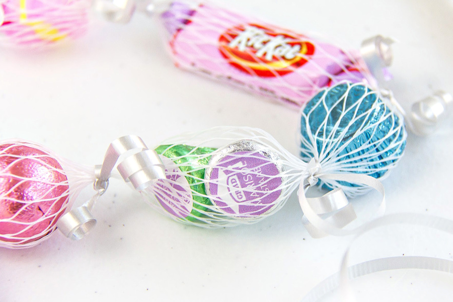 candy in a net sleeve tied with curling ribbon to make a lei