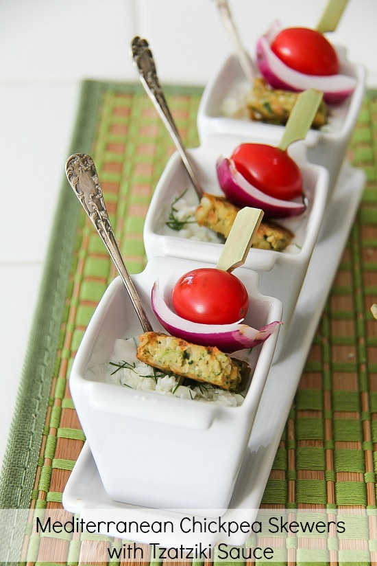 chickpea patties on skewers with red onion and tomato in a tzatziki dipping sauce