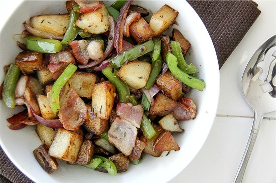 potato, bacon, green peppers, and onion in a white bowl