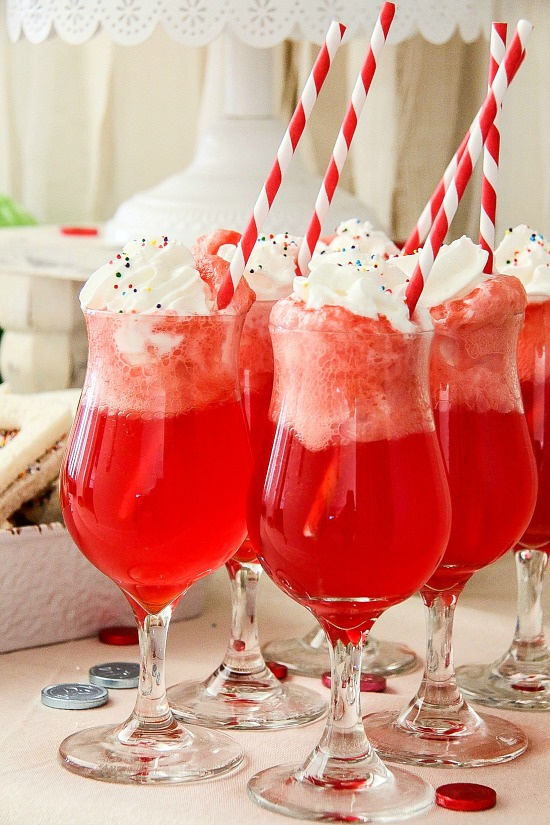 a red ice-cream float with rainbow sprinkles and red and white striped paper straws