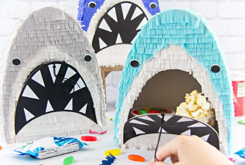 handmade shark pinatas that have pull strings and are filled with snacks