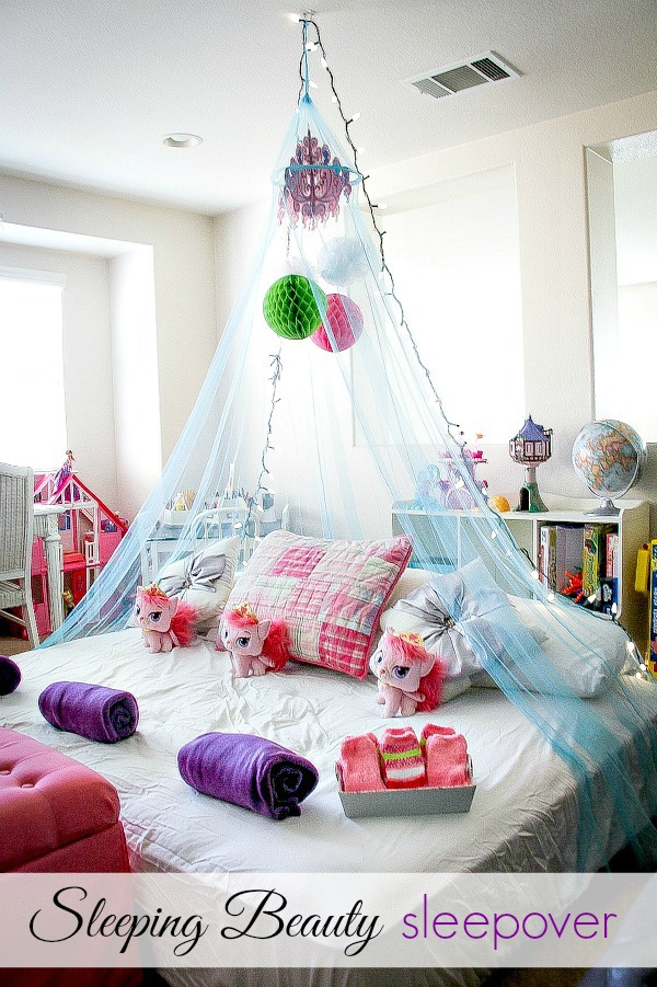 a mattress with a blue canopy, decorations, blankets and toys for a girls sleepover