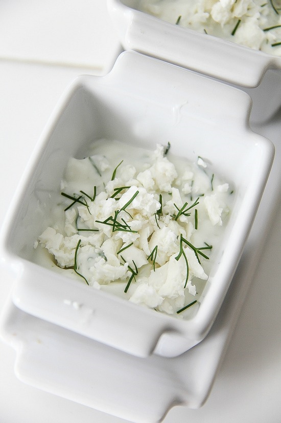 tzatziki dipping sauce with fresh chives in white bowls