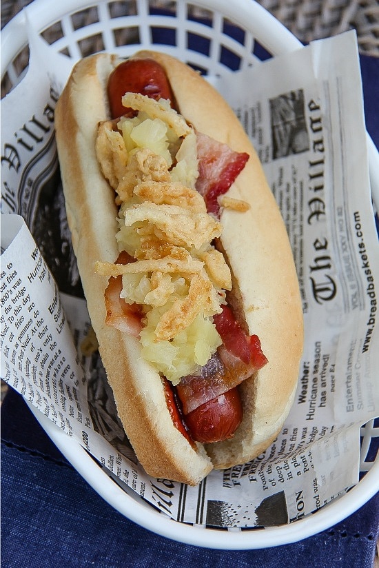barbecue sauce, bacon, pineapple, and french fried onions on top of a hot dog