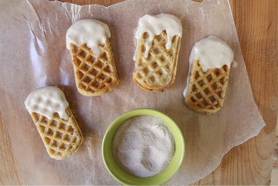 waffle sticks dipped in icing with a bowl of cinnamon sugar