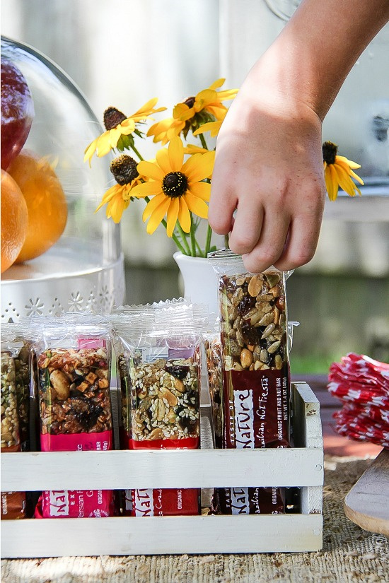 a child's hand reaching for a Taste of Nature granola bar