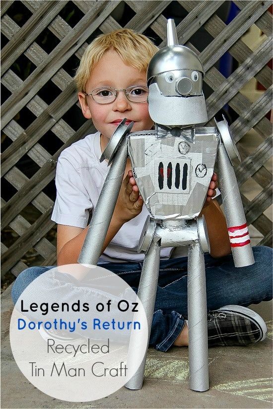 a boy holding a Tin Man from the Wizard of Oz that was made out of recycled materials