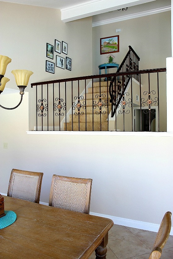 dining table with a staircase and photos on the wall