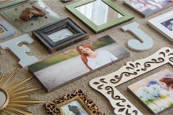 photos being laid out on the ground for a gallery wall